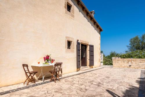 eine Terrasse mit einem Tisch und Stühlen neben einem Gebäude in der Unterkunft Casa Degli Aromi in Noto