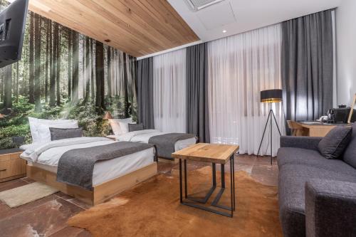 una camera d'albergo con due letti e un divano di Hotel Ramonda a Boljevac