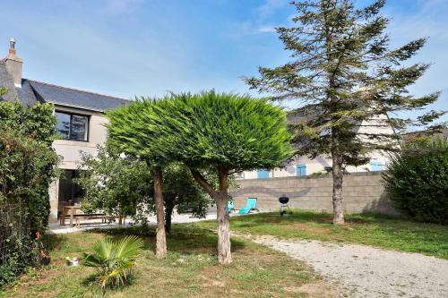 a house with two trees in front of it at LocaLise - M3C - La petite Bigoudène - Maison entièrement rénovée en duplex avec jardin - Tout à pied, plage, port, centre, commerces - Wifi inclus - Draps inclus - Animaux bienvenus in Le Guilvinec