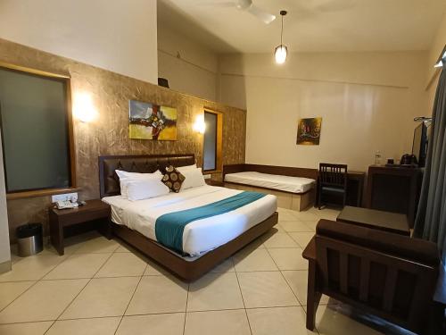 a hotel room with a bed and a television at Misty Meadows, Lonavala in Lonavala
