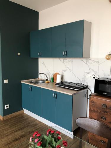 eine Küche mit blauen Schränken und einer Arbeitsplatte in der Unterkunft Apartmant in Smart Plaza in Kiew