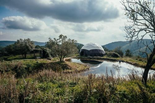a dome building next to a body of water at Reggioli- Appartamento Erborista in Gaiole in Chianti