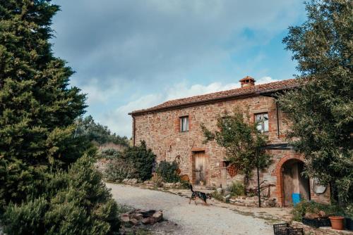 an old stone house with a dog in front of it at Reggioli- Appartamento Erborista in Gaiole in Chianti