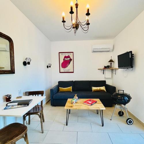 a living room with a couch and a table at LE FIGUIER in Cabestany