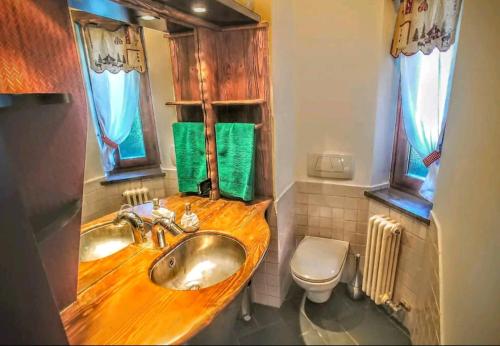 La salle de bains est pourvue d'un lavabo en bois et de toilettes. dans l'établissement Villa Panoramica - 200Mq - SPA - Giardino Privato - 0039-34893-66818, à Aoste