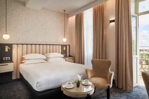Habitación de hotel con cama y silla en Best Western Premier Hotel des Vignes et des Anges, en Pauillac