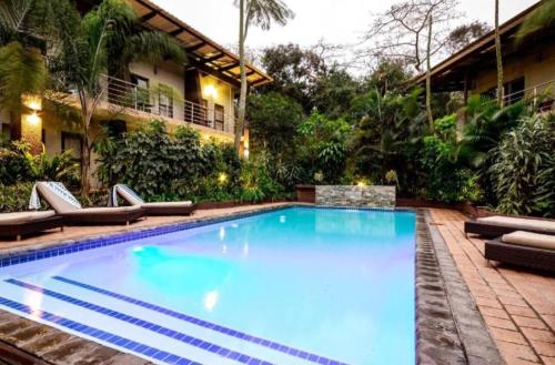 una gran piscina con sillas y un edificio en Forest Lodge, en St Lucia