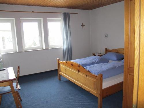 a bedroom with a bed with a cross on the wall at Gasthaus Adler in Wangen im Allgäu