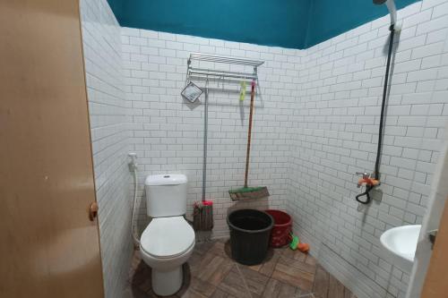La salle de bains blanche est pourvue de toilettes et d'un lavabo. dans l'établissement OYO Life 93158 Kost Asaka, à Serang