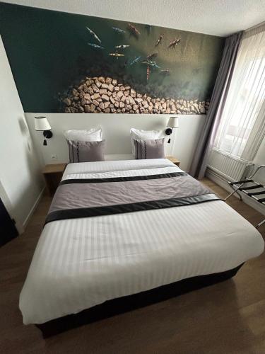 a bedroom with two beds and a fish painting on the wall at Logis Cris Hôtel et Restaurant, Lyon Sud-Est in Corbas