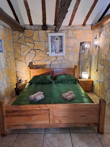 una camera con letto in legno su un muro di pietra di Family friendly house with a swimming pool Benkovac, Zagora - 21720 a Benkovac (Bencovazzo)