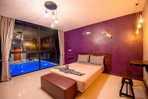 a bedroom with a bed and a window with a tub at Angela resort in Ban Benyaphat