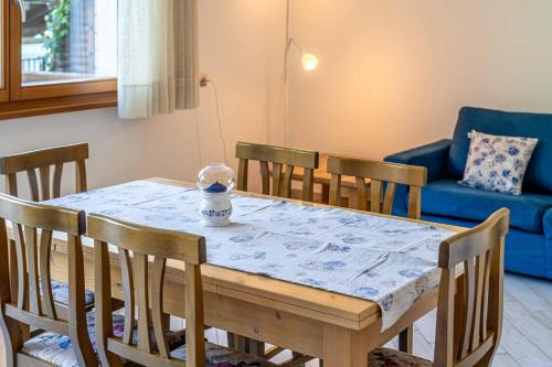 uma mesa de jantar com cadeiras e um sofá azul em Chalet Al Lago em Alleghe
