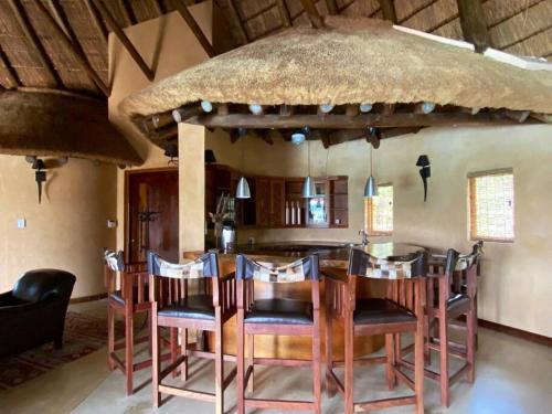 une salle à manger avec une grande table et des chaises dans l'établissement Reedbuck Lodge @Cyferfontein in Mabalingwe Reserve, à Bela-Bela