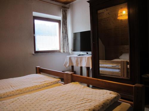 a bedroom with two beds and a large mirror at Gasthaus Adler in Wangen im Allgäu