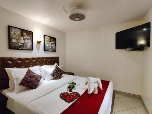 a hotel room with a bed with a stuffed elephant on it at Misty Meadows, Lonavala in Lonavala