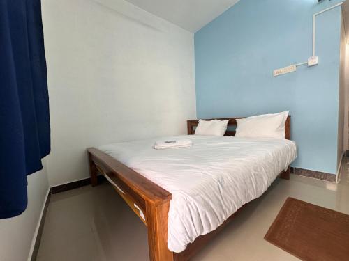 a small bedroom with a bed with white sheets at MPS Saai Residency in Tiruvannāmalai