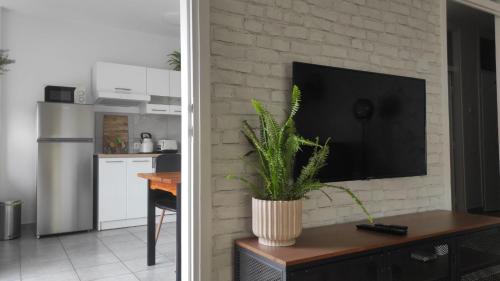 a living room with a tv on a brick wall at Apartman Majur in Slavonski Brod