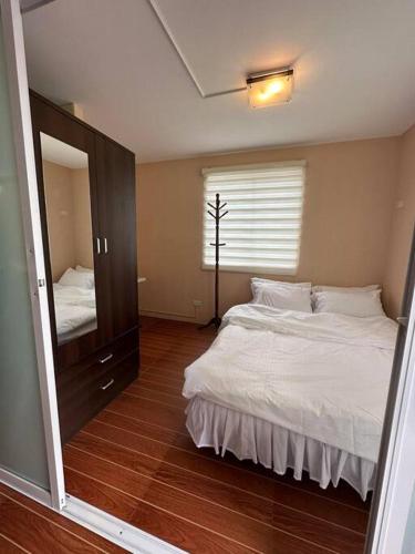 a bedroom with a bed and a large mirror at 7 mins to SM Premiere & Port to Samal - Condo in Davao City