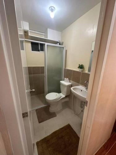 a bathroom with a toilet and a shower and a sink at 7 mins to SM Premiere & Port to Samal - Condo in Davao City