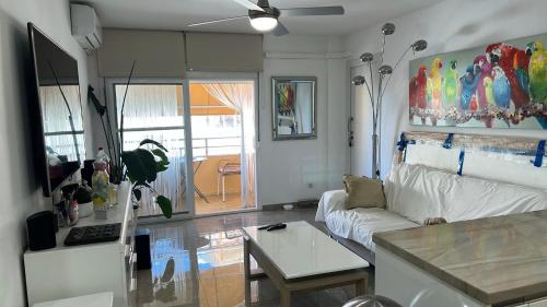 ein Wohnzimmer mit einer weißen Couch und einem Tisch in der Unterkunft Precioso dormitorio en el centro de Torremolinos in Torremolinos