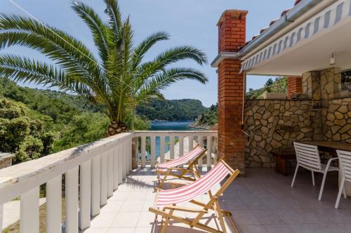 a balcony with chairs and a view of the water at House Ancica in Gornje Selo
