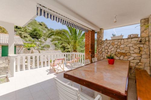a dining room with a table and chairs on a balcony at House Ancica in Gornje Selo