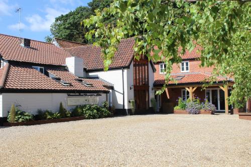 a house with red roofs and a driveway at The Black Swan Inn in Norwich