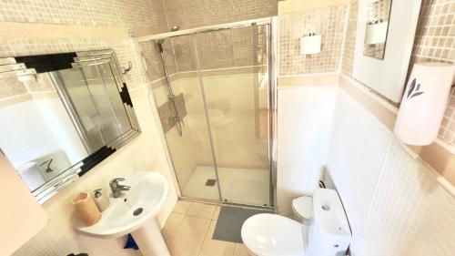 a bathroom with a shower and a sink and a toilet at ALCAMAR Brand apartment with 2 bedroom and private bathroom near the sea! in Alcalá