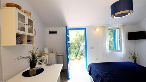 a white bedroom with a bed and a window at Room Ivana in Budva