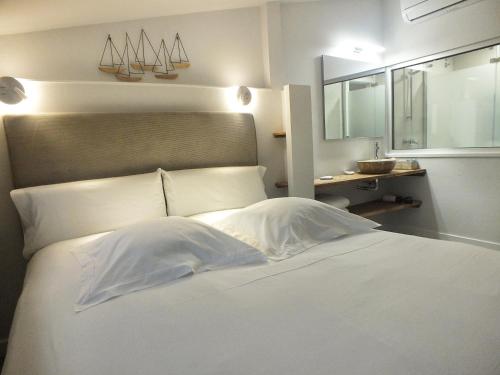 a bedroom with a white bed with a mirror at El Cielo de Cebreros in Cebreros