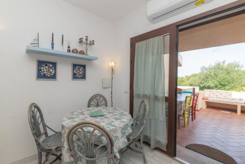 a dining room with a table and chairs and a balcony at Appartamento Palau Sole in Palau