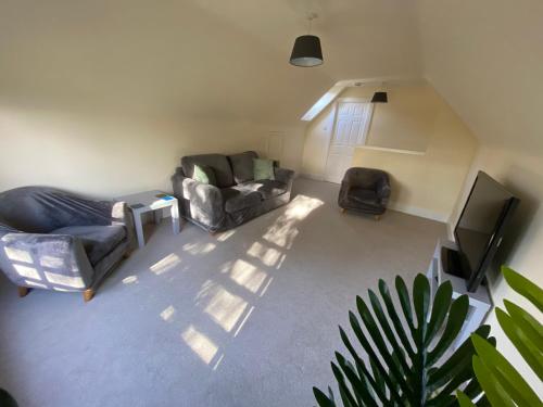 a living room with two couches and a television at The Lodge at Woodend in Kemnay