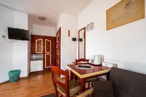a living room with a table and a kitchen at Hotel Sugas in Sfântu-Gheorghe