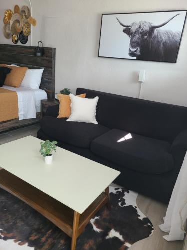 a living room with a couch and a cow on the wall at Modern Studio Retreat with King Bed - Cozy Comfort in Pahokee