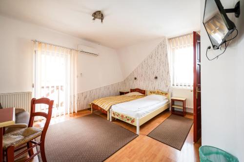 a bedroom with a bed and a tv on the wall at Hotel Sugas in Sfântu-Gheorghe