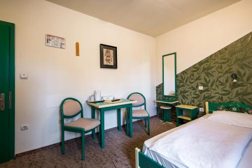 a hotel room with a bed and a table and chairs at Hotel Sugas in Sfântu-Gheorghe