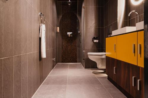 a bathroom with a toilet and a yellow cabinet at De Jonker Urban Studios & Suites in Amsterdam