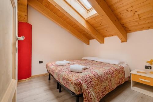 a bedroom with a bed with two towels on it at Sarca Lodge Val Rendena in Dare