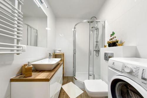 uma casa de banho com um lavatório e uma máquina de lavar roupa em Cracow City Premium Apartment em Cracóvia