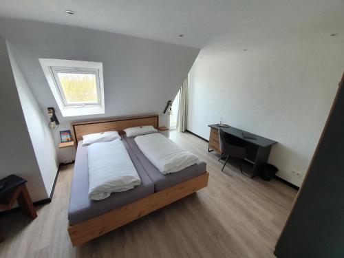a bedroom with a bed and a desk in it at Meerzeit Strandhotel in Neuharlingersiel