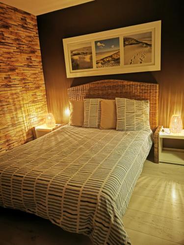 ein Schlafzimmer mit einem Bett mit Ziegelwand in der Unterkunft Escapade charentaise in Aigrefeuille-dʼAunis