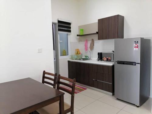 a kitchen with a refrigerator and a table and a dining room at Mesahill Nilai 2 Room Condo - Fast wifi, Amazing Pool & TV in Nilai