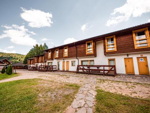 Une rangée de bâtiments avec des tables de pique-nique devant dans l'établissement SKI CIERNY BALOG, à Čierny Blh