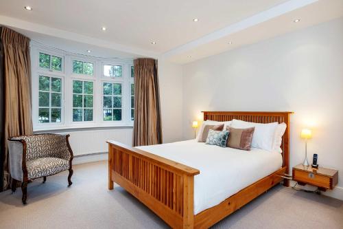 um quarto com uma cama, uma cadeira e janelas em Veeve - Majestic Oasis em Londres