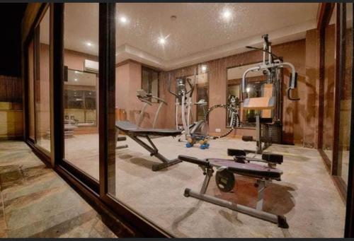 a room with a gym with a treadmill and a mirror at Renovated Farmhouse with Pool, Jacuzzi, Gym in the Village Centre in Nadur