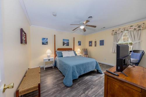 1 dormitorio con 1 cama y TV de pantalla plana en Cosgrove's Cove, en Pine Knoll Shores