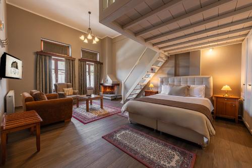 a bedroom with a bed and a living room at Ef Zin Hotel Arachova in Arachova