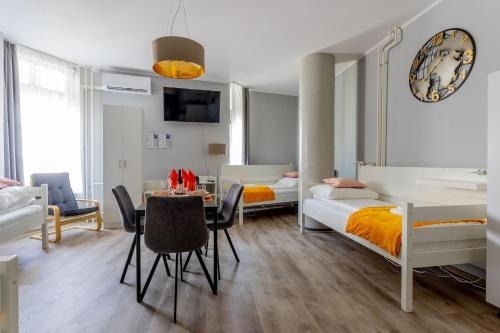 Downtown Apartment House Orange في بودابست: غرفة نوم بسرير وطاولة وكراسي