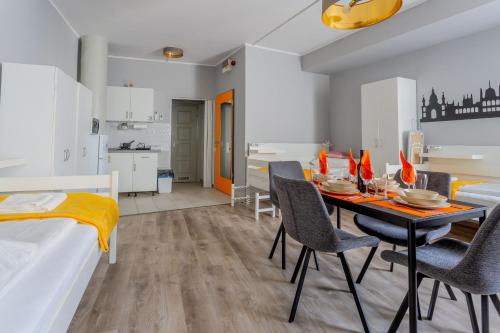 Downtown Apartment House Orange في بودابست: غرفة طعام ومطبخ مع طاولة وكراسي